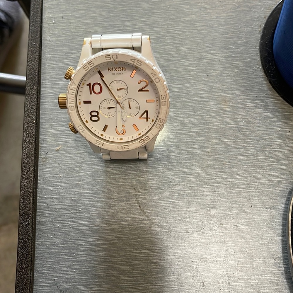 Nixon 51-30 white ceramic with gold underlay. Band has wear but shows gold